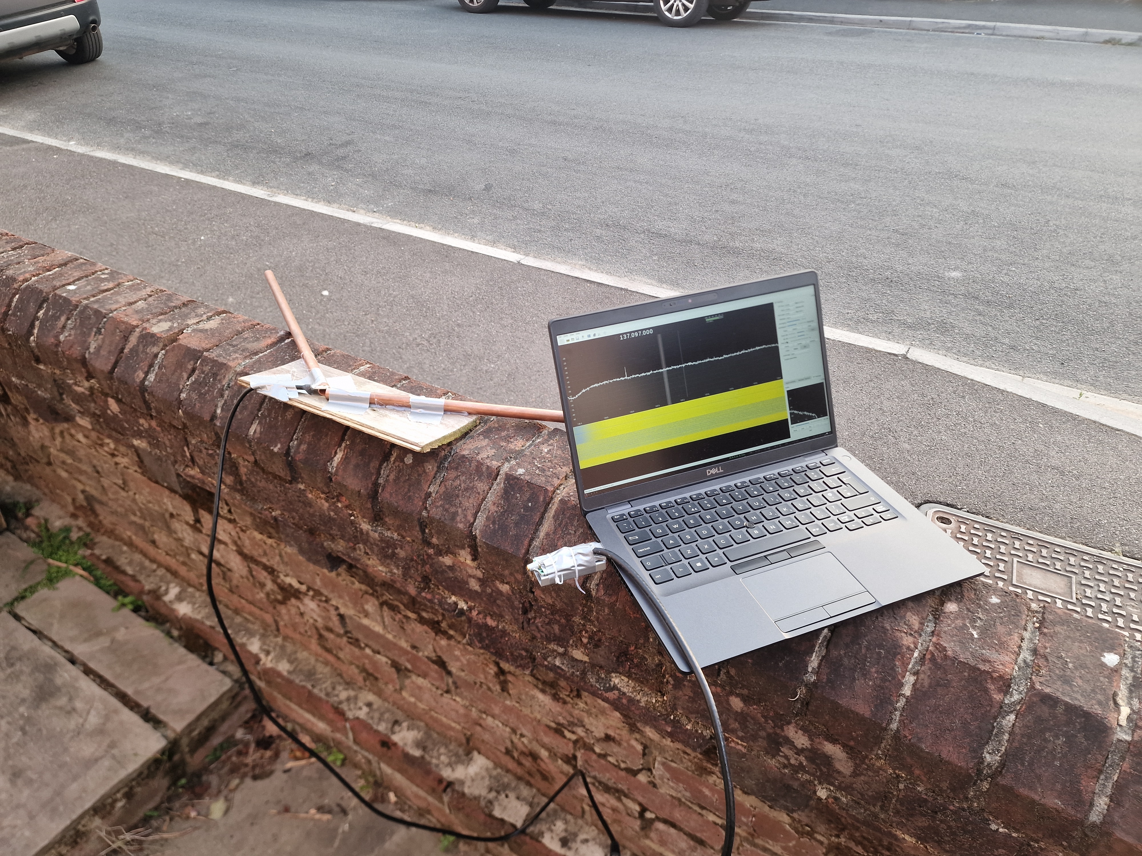 a laptop and the antenna on a brick wall